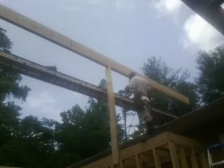 Carpenter setting a ridge beam over a new addition frame — Ice Dam Removal by Roofing Brothers in Westpoint