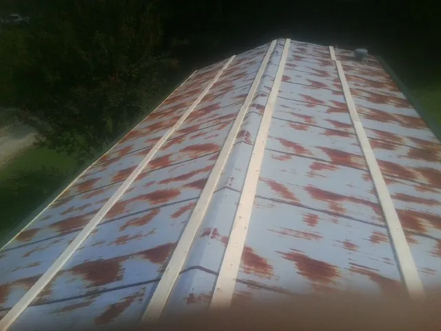 Rusted metal roof panels with new wood purlins before replacement — Storm Damage Roof Repair in Westpoint by Roofing Brothers