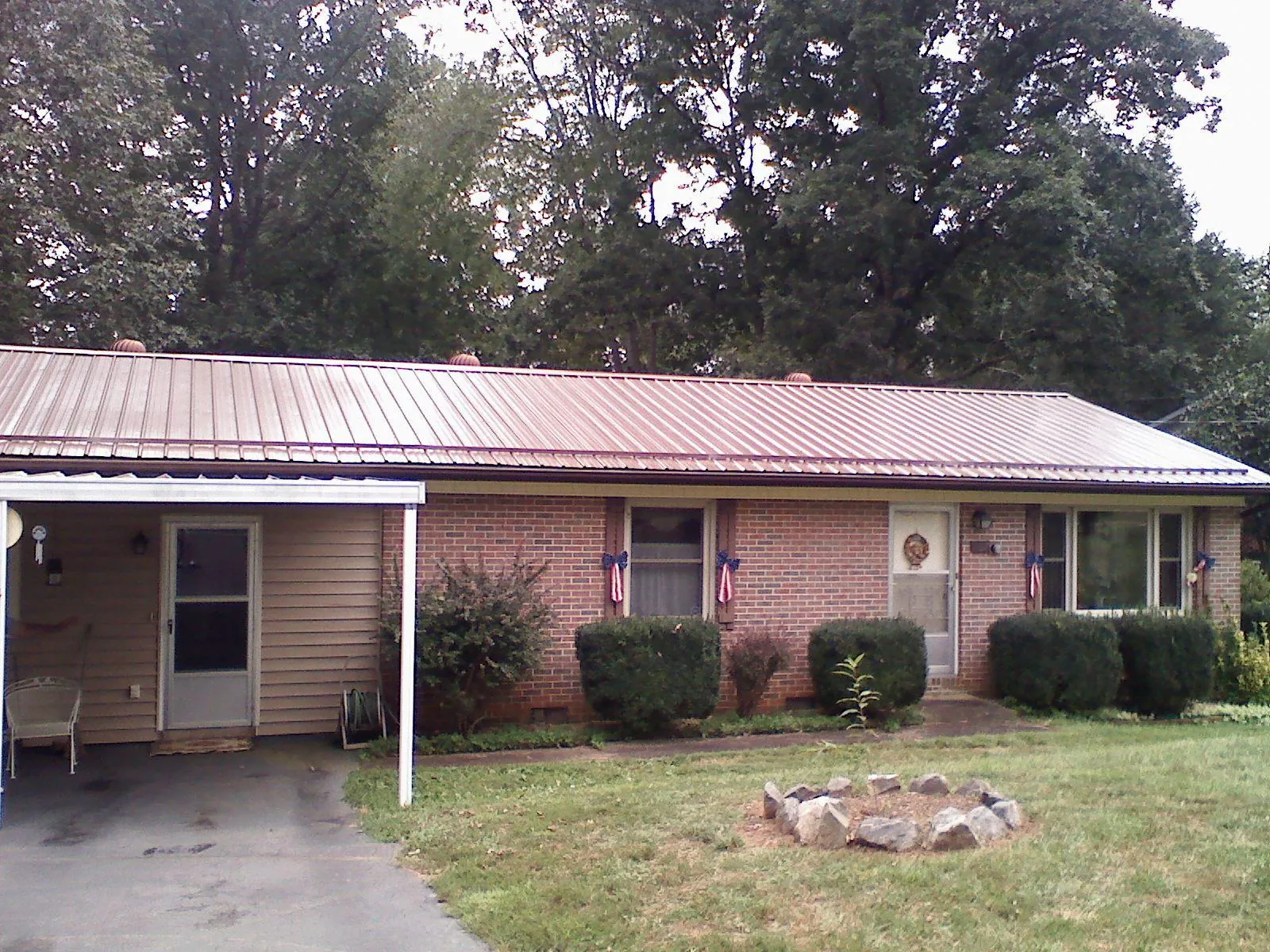 Bronze metal roof and carport on a brick ranch home — Roof Repair work by our crew in Westpoint